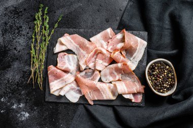 Biber ve kekik ile taze domuz pastırması dilimleri. Organik çiğ et. Siyah arka plan. Üst görünüm.