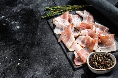 Biber ve kekik ile taze domuz pastırması dilimleri. Organik çiğ et. Siyah arka plan. Üst Manzara. Boşluğu kopyala.