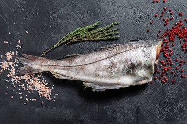 Başsız çiğ mezgit balığı. Siyah arka plan. Üst görünüm.