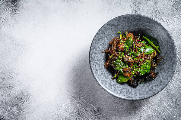 Soba noodles with beef, carrots, onions and sweet peppers. Stir fry wok. Gray background. Top view. Copy space.