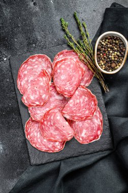 Siyah kesim tahtasında İspanyol salam salçamı. Siyah arka plan. Üst görünüm.