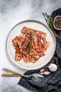 Kızarmış domuz pastırması ve kekik. Organik et. Gri arka plan. Üst görünüm.