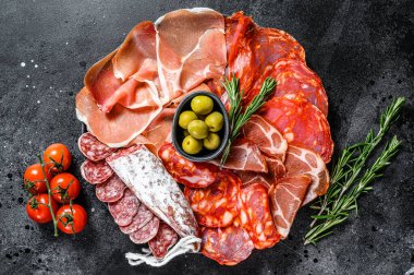 İspanyol soğuk et çeşitleri. Chorizo, fuet, LOMO, jamon Iberico, zeytin. Siyah arka plan. Üst görünüm