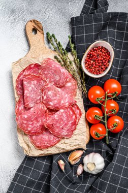 Çiğ tütsülenmiş salam sosisi dilimleri. Gri arka plan. Üst görünüm.