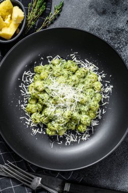 Fesleğen ıspanak soslu ve parmesanlı Gnocchi. İtalyan patates ezmesi. Siyah arka plan. Üst görünüm.