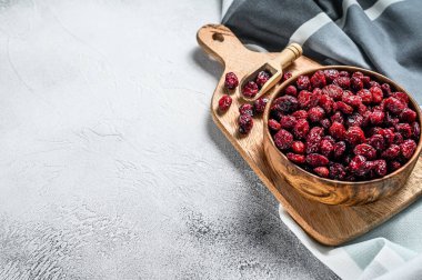 Ahşap bir kasede kurutulmuş kırmızı kızılcık. Gri arka plan. Üst Manzara. Boşluğu kopyala
