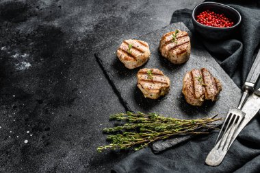 Yumuşak kemiksiz ızgara domuz pirzolası. Biftek filetosu. Siyah arka plan. Üst Manzara. Boşluğu kopyala.