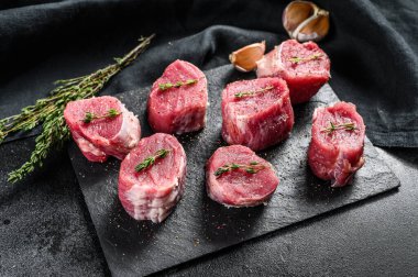 Çiğ domuz madalyonu bifteği. Domuz eti fileto. Siyah arka plan. Üst görünüm.