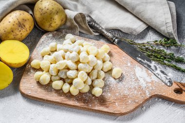 El yapımı gnocchi di patata, geleneksel İtalyan makarnası pişirmeye hazır. Gri arka plan. Üst görünüm.