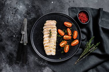 Kızarmış tavuk göğsü ve taze vişneli domates. Sağlıklı diyet yemekleri. Siyah arka plan. Üst görünüm.