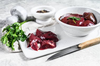 Bir kasede çiğ tavuk ciğeri. Gri arka plan. Üst görünüm.