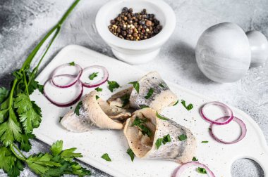 Maydanozlu ve soğanlı ringa turşusu. Gri arka plan. Üst görünüm.