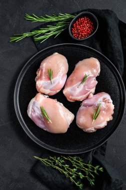 Çiğ tavuk budu fileto derisi olmadan. Çiftlik hayvanları eti. Siyah arka plan. Üst görünüm.