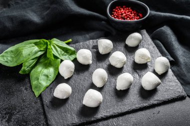 Mini mozarella peyniri topları, Caprese salatası için malzemeler. Siyah arka plan. Üst görünüm.