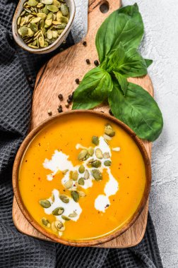 Kremalı balkabağı kreması çorbası ve kabak çekirdeği. gri arka plan. Üst görünüm.