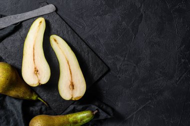 Armut ve armut yarıları. Çiftlik eko meyveleri. Siyah arka plan. Üst Manzara. Metin için boşluk.