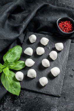 Mini mozarella peyniri topları, Caprese salatası için malzemeler. Siyah arka plan. Üst görünüm.