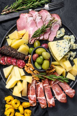 Jambon, prosciutto, salam, mavi peynir, mozarella ve zeytinli Antipasto tabağı. Siyah arka plan. Üst görünüm.