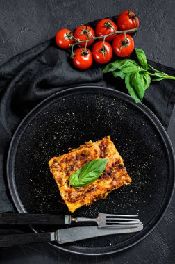 Domates soslu ve biftekli ev yapımı İtalyan lazanyası. Siyah arka plan. Üst görünüm.