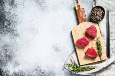 Çiğ kırmızı ton balığı bifteği. Gri arka plan. Üst Manzara. Metin için boşluk.