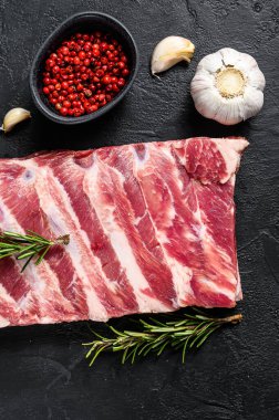 Biberiye ve sarımsaklı taze domuz pirzolası. Siyah arka plan. Üst görünüm.