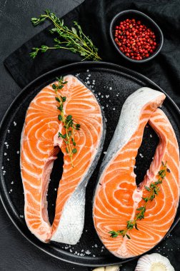 Baharatlı bir tabakta somon bifteği. Atlantik balığı. Siyah arka plan. Üst görünüm.