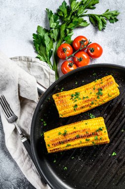 Kızartma tavasında organik ızgara mısır. Organik çiftlik sebzeleri. Gri arka plan. Üst görünüm.