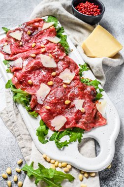 Çiğ mermerden yapılmış Carpaccio. Gri arka plan. Üst görünüm.