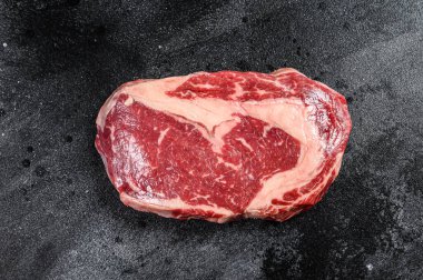 Çiğ mermer et, biftek, pirzola. Siyah Angus kaburgası. Siyah arka plan. en üstteki görünüm.