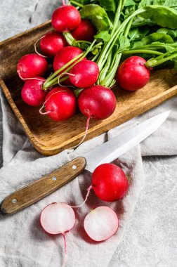 Tahta bir kasenin içinde taze turplar. Çiftlik organik sebzeler. Gri arka plan. Üst görünüm.