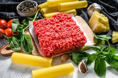 Ingredients for cooking cannelloni pasta with ground beef. Italian cuisine. Gray background. top view. clipart