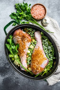 Hindi yahnisi. Maydanozlu, bezelyeli, kerevizli ve patatesli but tarifi. Gri arka plan. Üst görünüm.