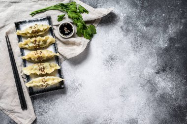 Seramik tabakta Kore böreği. Gri arka plan. Üst Manzara. Metin için boşluk