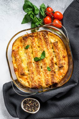 Beşamel soslu doldurulmuş cannelloni. Etli makarna, krem soslu, peynirli. Gri arka plan. en üstteki görünüm.