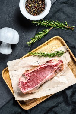 Kemikle kesilmiş biftek. Siyah arka plan. Üst görünüm.