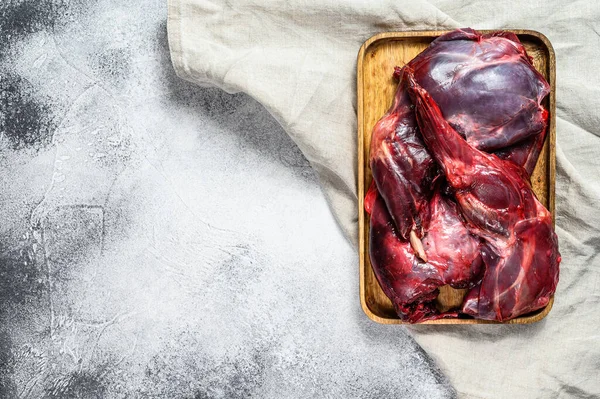 Rabbit meat. Raw fresh farm rabbit on a wooden table with vegetables and spices. Top view. Copy space.