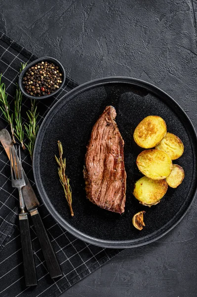 Beef marble flank steak medium rare. Black background. Top view.