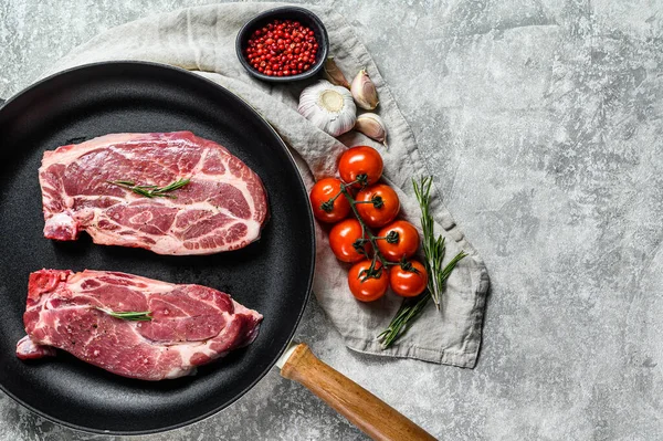 新鲜的猪肉牛排放在煎锅里 农场肉块 灰色背景 顶部视图 案文的篇幅 — 图库照片