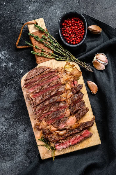 Nakrájený Žebírkový Steak Sekací Tabuli Středně Propečený Černé Pozadí Pohled — Stock fotografie