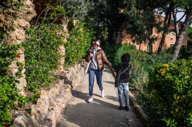 View on the park Guel, designed by architect Antoni Gaudi. Tourists walking along the paths. 03.01.2020 Barcelona, Spain.