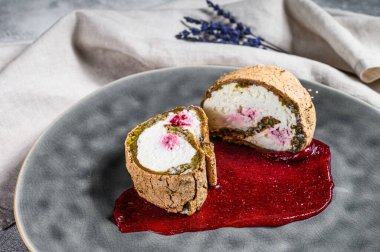 Çilek reçeli ve kremalı tatlı rulosu dilimi. Gri arka plan. Üst görünüm.