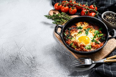 Kızarmış yumurta ve domateslerle kahvaltı. Shakshuka tavada. Geleneksel Türk yemekleri. Gri arka plan. Üst Manzara. Boşluğu kopyala.