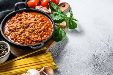 İtalyan spagetti bolonezi için yemek malzemeleri. Çiğ makarna, fesleğen, kıyma, domates. Gri arka plan. Üst Manzara. Boşluğu kopyala.