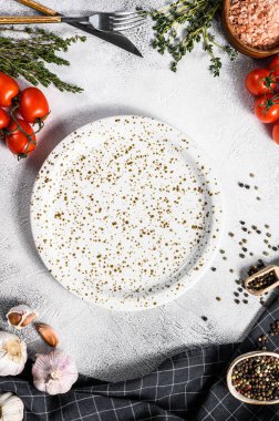 Taze çiğ sebze ve sebzelerin ortasında beyaz boş bir tabak. Sağlıklı, temiz yemek, vejetaryen, diyet yemek konsepti. Beyaz arka plan. Üst Manzara. Boşluğu kopyala.