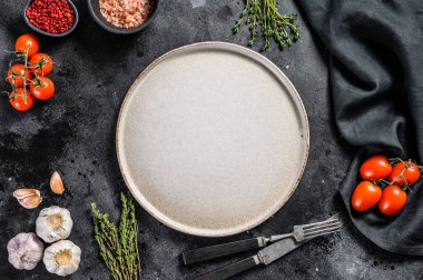 Taze çiğ sebze ve sebzelerin ortasında beyaz boş bir tabak. Sağlıklı, temiz yemek, vejetaryen, diyet yemek konsepti. Siyah arka plan. Üst Manzara. Boşluğu kopyala