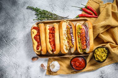Sosisli sandviçler ve çeşitli malzemeler. Domuz ve sığır etli sosisli nefis sosisler. Beyaz arka plan. Üst görünüm