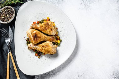 Beyaz tabakta sebzeli ızgara tavuk budu. Beyaz arka plan. Üst Manzara. Boşluğu kopyala.