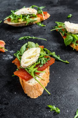 Peynirli sandviç, roka ve armut reçeli. Siyah arka plan. Üst görünüm.