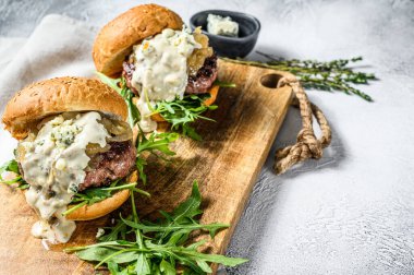 Mavi peynirli ev yapımı hamburger, mermer biftek, soğan reçeli ve roka. Gri arka plan. Üst Manzara. Boşluğu kopyala.