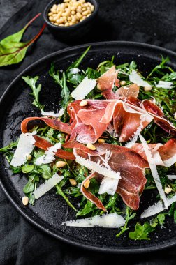 Parmalı salata, jambon, roka ve parmesan peyniri. Siyah arkaplan, üst görünüm